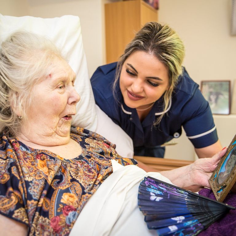 A carer sitting with a resident at an MG care home in Tunbridge Wells